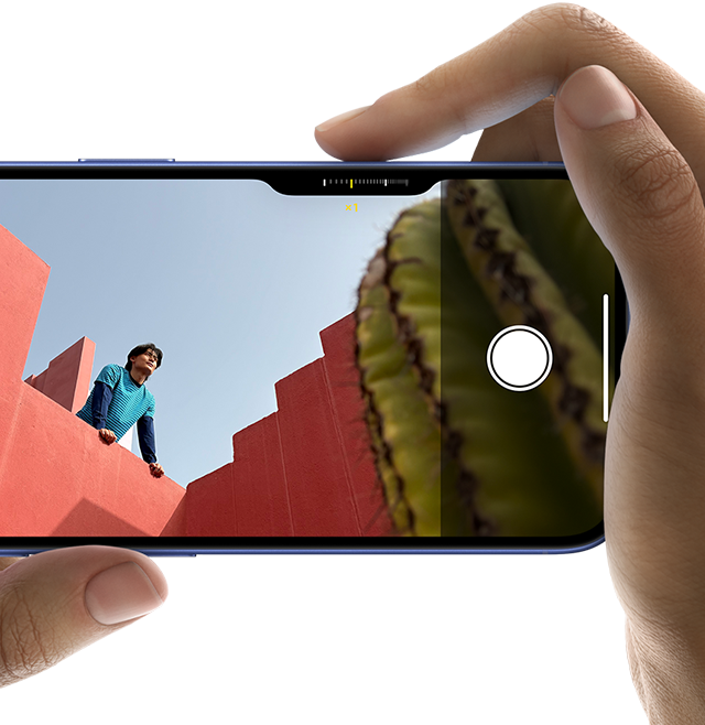 صورة لوحدة التحكم في الكاميرا في iPhone&nbsp;16 تظهر كيف ينزلق الإصبع الأيمن على جانب الهاتف لضبط إعدادات الكاميرا